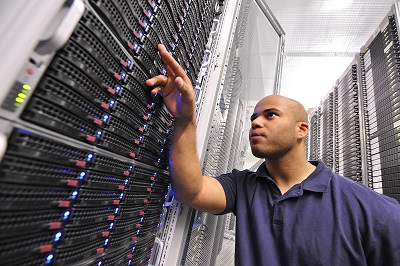 Strato Mitarbeiter in Rechenzentrum vor Server Rack